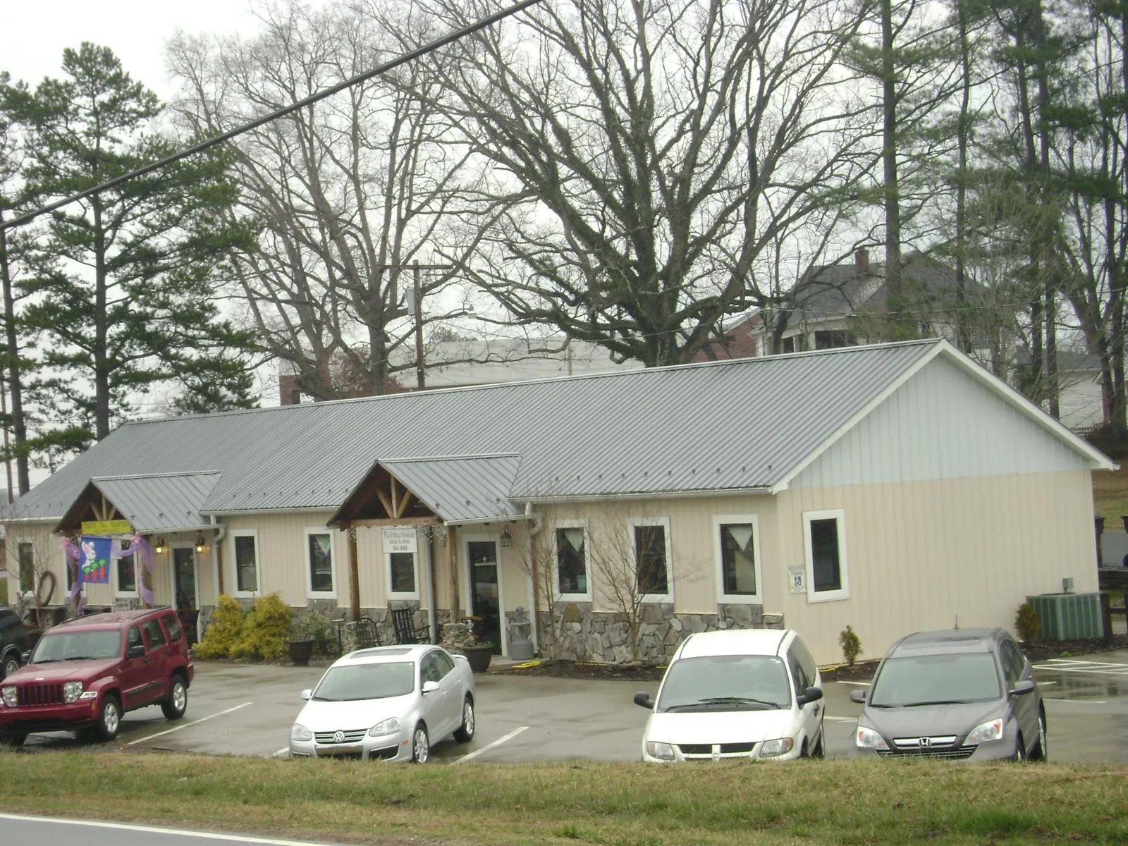 Gray metal roof with timber entry brackets on a small commercial building in Plainfield